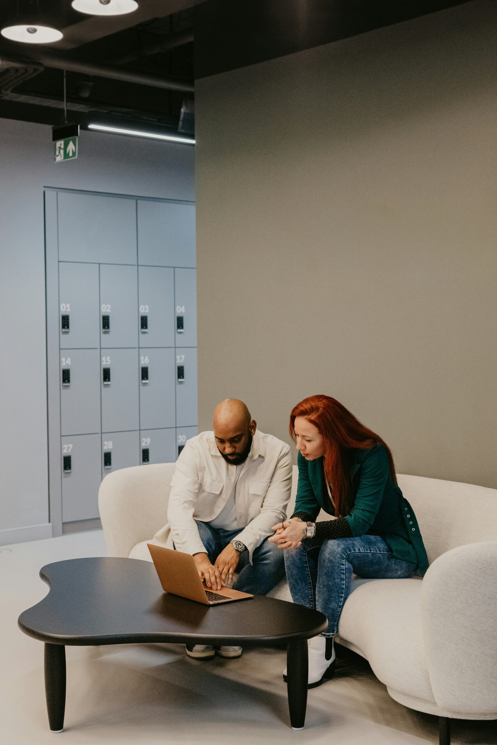 Two colleagues working together on a laptop in an office